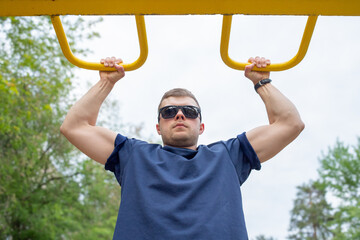 young man exercising on outdoor exercise equipment