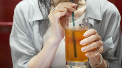 カフェでアイスティーを飲む女性