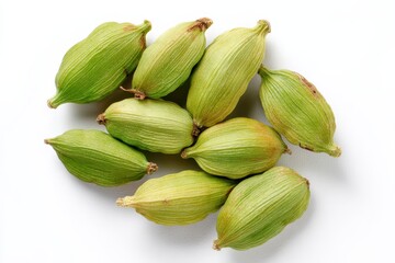 Top view of cardamom seeds against a white backdrop including pods
