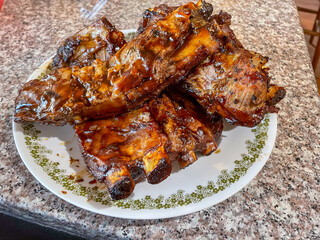 A Family dinner of Pork Strips on a plate from a BBQ grilled and ready to serve with sauce and...