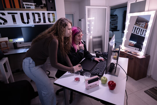 A collaborative environment in a modern studio with two creative professionals working together on a project at a desk