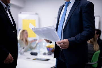 Business professionals meeting in a modern office focusing on documents and collaborative...