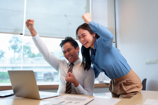 Asian adult business people celebrate success teamwork achievement victory looking laptop office workplace results