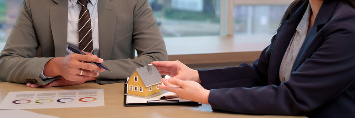 Business professionals discuss real estate property investment house model concept meeting in office