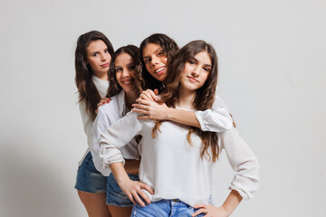 Group of cheerful young women embracing and smiling together