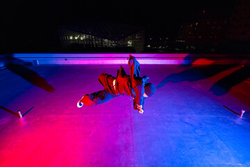 ビル屋上でアクロバティックなポーズを決めるダンサーの若者