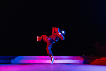 ビル屋上でアクロバティックなポーズを決めるダンサーの若者