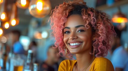 Smiling woman with pink curly hair in a warmly lit bar setting