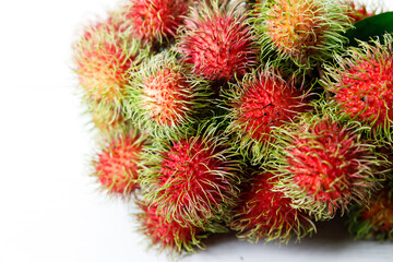 Fresh rambutan fruit on white wooden table.