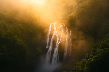 A waterfall in a rainforest at sunset mist catching the golden light as tropical birds return to their nests