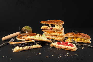 Waffles with fruit on a black background. Close-up.
