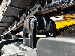 Close-up view of construction machine track components showcasing roller systems and structural...