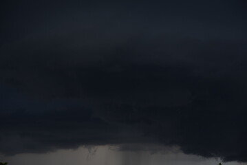 Dramatic dark storm rain clouds black sky background. Dark thunderstorm clouds rainny atmosphere. Meteorology danger windstorm disasters climate. Dark cloudscape storm disaster gloomy gray cloud sky