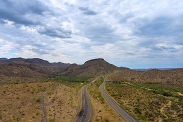 Divided highway crossing desert terrain in Maricopa County, Arizona rocky mountains rise in Arizona...