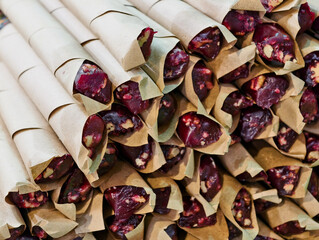 Sweet delight of artisanal candies wrapped in rustic paper at a bustling market during sunny...