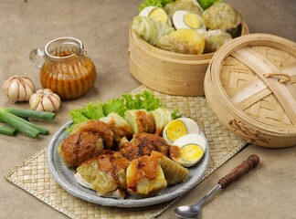 Siomay Bandung. Fish cake dumplings with potato, egg, and cabbage roll served with peanut, chili, sweet soy sauces and lime