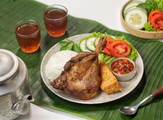 Bebek Goreng. Fried Duck Rice is duck meat that is fried and served with fresh vegetables plus a picnic