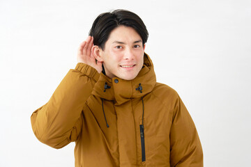 ダウンジャケットを着た男性　耳を澄ます　白背景