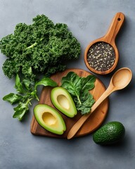 Vibrant healthy ingredients of kale, quinoa seeds, and ripe avocado halves are attractively displayed on a wooden board for healthy meal preparation at home.