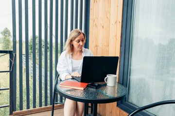 woman takes her work outside, creating a refreshing and inspiring outdoor home office for increased...