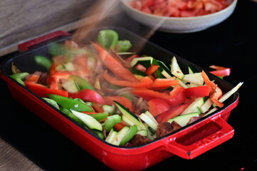 Cooking Preparation on Home Induction Stove – Red Pan with Fresh Ingredients for a Homemade Lunch