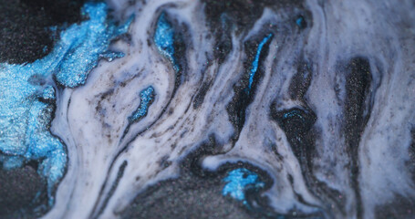 Stream spilling. Flowing ink. Defocused blue white color water sparkling pigment dark black stains...