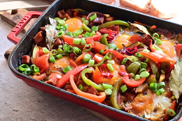 A hearty homemade Czech-style lecsó (lečo), featuring colorful bell peppers, fried egg, slices of sausage, and fresh bread, served straight from the pot.