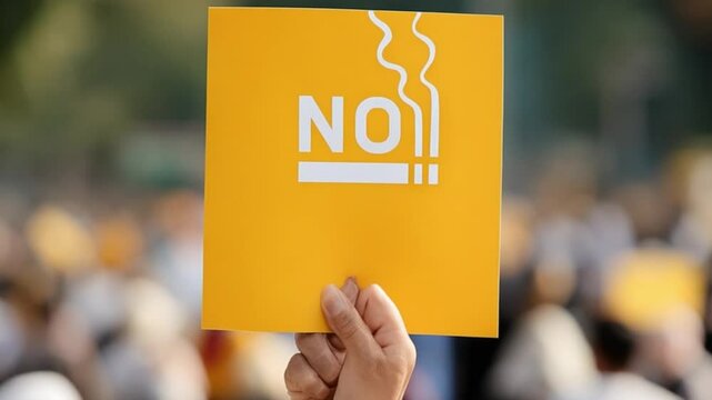 Prohibition Proclamation: A hand firmly holds a yellow sign, displaying the assertive message "NO", a visual declaration against the detrimental act of smoking.