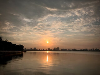 Fototapeta premium Golden Twilight Reflection on West Lake, Hanoi, Vietnam – Tranquil Sunset Lake Landscape