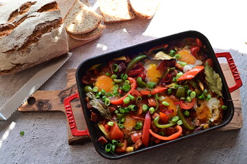 A hearty homemade Czech-style lecsó (lečo), featuring colorful bell peppers, fried egg, slices of sausage, and fresh bread, served straight from the pot.