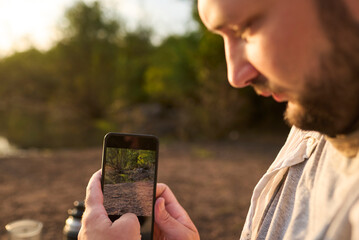 Traveler taking a photo at sunrise to share it on his social networks. Concept: use of technology connects us even in remote locations. El Palmar National Park, Entre Rios, Argentina.