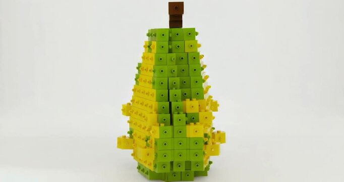 A pear-shaped structure built from small, colorful, interlocking plastic blocks