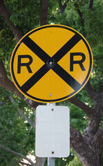RAILROAD CROSSING road sign with faded  illegible no parking sign beneath