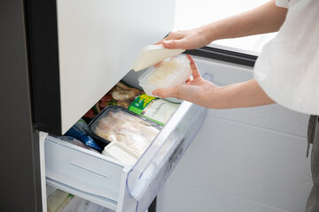Person organizing food in a freezer drawer