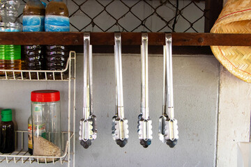 Aluminum food tongs or ice Hanging from small wooden beam to keep things organized in kitchen....