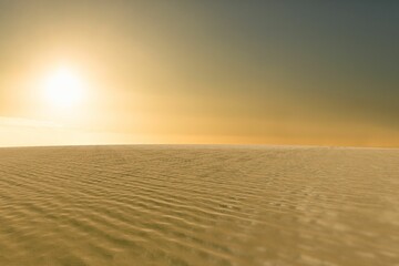 Flat design desert landscape is showing rippled dunes casting shadows under warm glowing sun