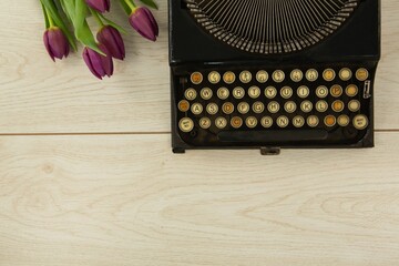Typewriter and flowers on table