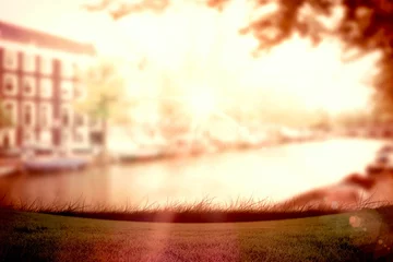 Gordijnen Flat design showing sunlit canal water flowing past grassy bank, brick facade, foliage, lens flare © vectorfusionart