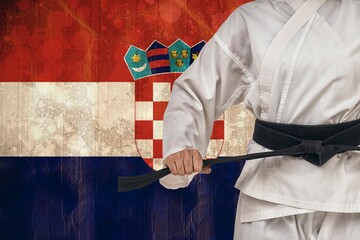 Midsection of martial artist tying belt against Croatian Flag