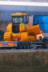 Heavy construction machine tied on trailer truck