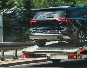 Tow truck with car on flatbed in neighborhood
