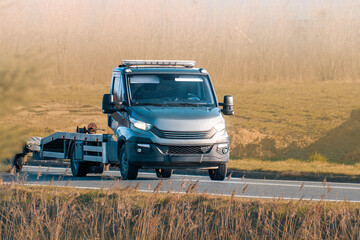 Orange tow truck driving on country road