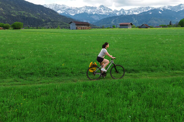 Woman riding bicycle through peaceful valley