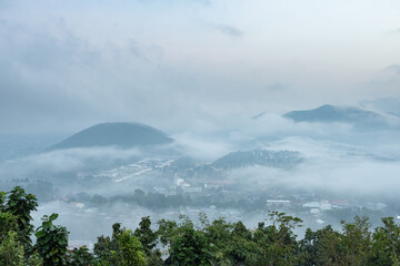 The city and mountains are covered in fog.