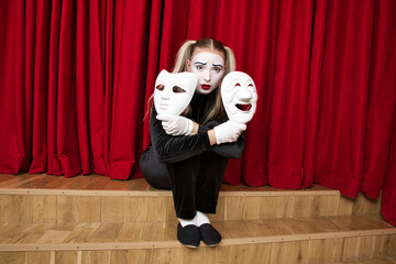 The focus is on a mime artist with a mask in his hand.