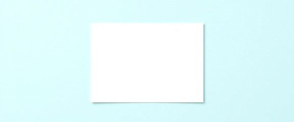 Fototapeta premium Blank white paper sheet centered on a soft light blue background