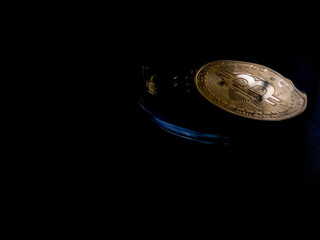 Bitcoin token rests against black background