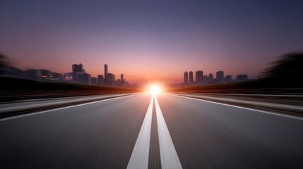 Open asphalt road leading toward a blurred city skyline at sunset with bright sun flare