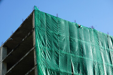 Green slanding net is used to cover the electric train base structure, used for temporary wall...