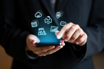 A businessman interacts with digital icons on a smartphone screen